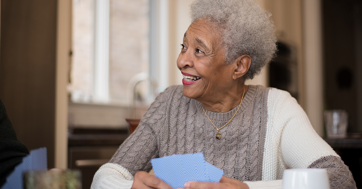 Senior woman of African descent playing cards